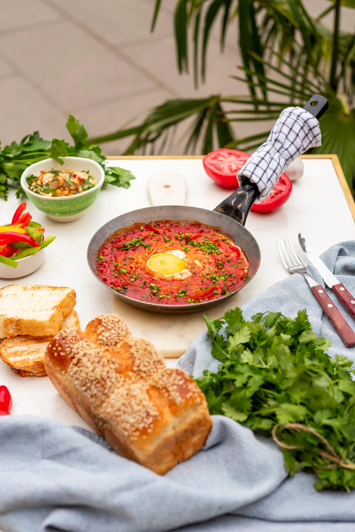 Shakshuka z jajkiem i szczypiorkiem, podana z brioche